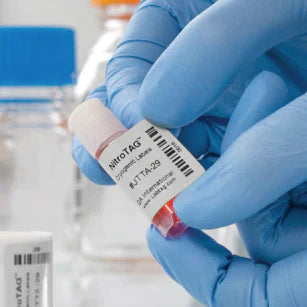 a gloved hand shown tagging a small vial